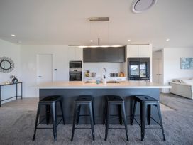 A kitchen with a large island and seating at Te Anau Holiday Home in Te Anau