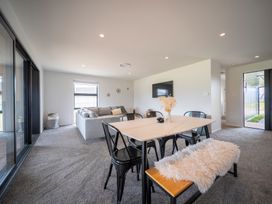 A living room with a sofa and dining table at Te Anau Holiday Home in Te Anau