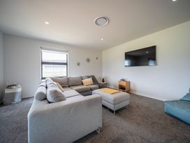 A living room with a sofa and television at Te Anau Holiday Home in Te Anau
