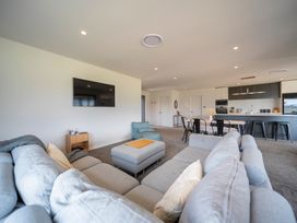 A living room with a sofa and television at Te Anau Holiday Home in Te Anau