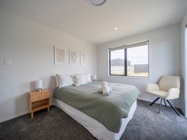 A bedroom with a bed and nightstand at Te Anau Holiday Home in Te Anau