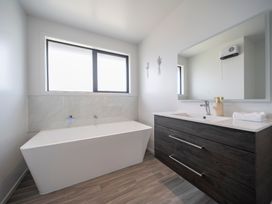 A bathroom with a bathtub and sink at Te Anau Holiday Home in Te Anau
