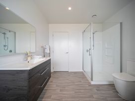 A bathroom with a sink, shower, and toilet at Te Anau Holiday Home in Te Anau