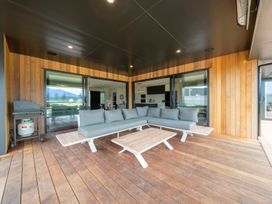 An outdoor patio with a sofa and coffee table at Te Anau Holiday Home in Te Anau