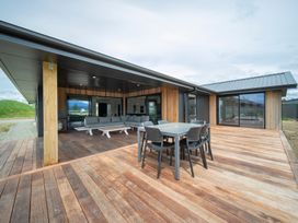 An outdoor seating area with a table and chairs at Te Anau Holiday Home in Te Anau