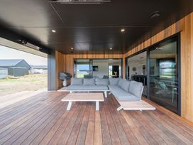 An outdoor lounge area with a sofa and table at Te Anau Holiday Home in Te Anau