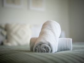 A bed with rolled towels at Te Anau Holiday Home in Te Anau