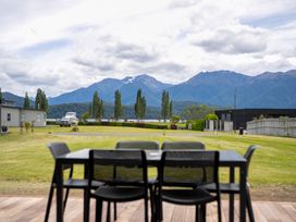 An outdoor area with a table and view of mountains at Te Anau Holiday Home in Te Anau