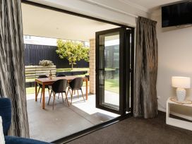 A living room with a view of an outdoor dining area at New Plymouth in New Plymouth