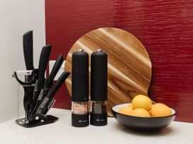 A kitchen with knives, salt and pepper mills, cutting board, and a bowl of oranges at New Plymouth, New Plymouth