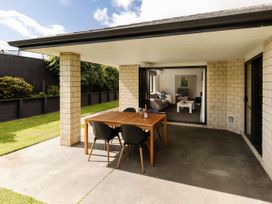 An outdoor patio with a dining table and chairs at New Plymouth