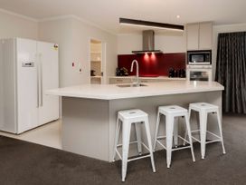 A kitchen with a refrigerator and stools at New Plymouth in New Plymouth