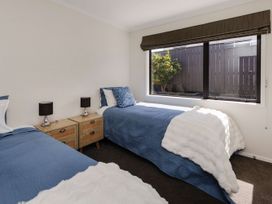 A bedroom with two beds and a window at New Plymouth