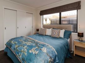 A bedroom with a bed and bedside table at New Plymouth