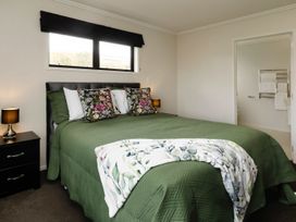 A bedroom with a bed and bedside table at New Plymouth