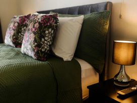 A bed with pillows and a lamp on a nightstand at New Plymouth