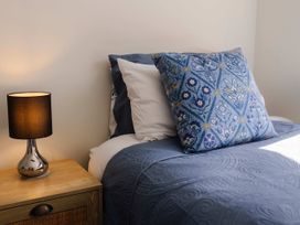 A bedroom with a bed and lamp at New Plymouth in New Plymouth