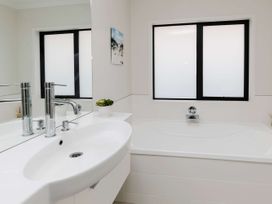 A bathroom with a bathtub and sink at New Plymouth