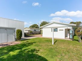 A house with a garage in an outdoor area at Whangamata