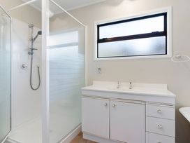 A bathroom with a shower and sink at Whangamata