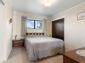 A bedroom with a bed and window at Whangamata