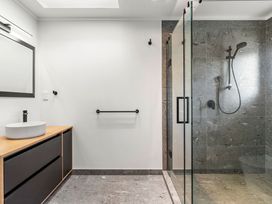 A bathroom with a sink and shower at Whangamata