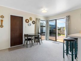 A dining room with a table and chairs at Whangamata