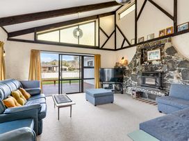 A living room with sofa and television at Whangamata
