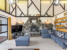 A living room with a fireplace and television at Whangamata