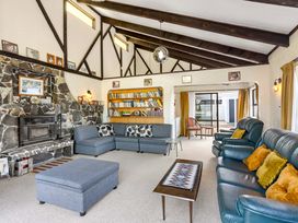 A living room with a couch and a fireplace at Whangamata