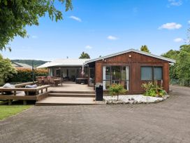 An outdoor view of a house with a deck and seating area at Paradise At 471 - Rotorua Holiday Home in Rotorua