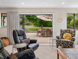 A living room with a view of an outdoor dining area at Paradise At 471 - Rotorua Holiday Home, Rotorua