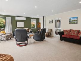 A living room with sofa, armchairs and coffee table at Paradise At 471 - Rotorua Holiday Home, Rotorua