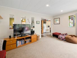 A living room with television and bookshelves at Paradise At 471 - Rotorua Holiday Home, Rotorua