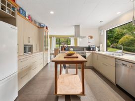 A kitchen with a refrigerator, stove, and kitchen island at Paradise At 471 - Rotorua Holiday Home Rotorua