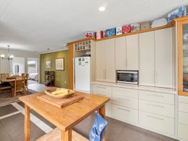 A kitchen with dining table and chairs at Paradise At 471 - Rotorua Holiday Home in Rotorua
