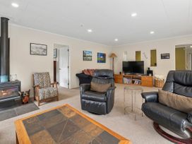 A living room with a fireplace and seating at Paradise At 471 - Rotorua Holiday Home Rotorua