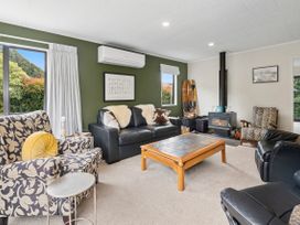 A living room with a sofa and armchairs at Paradise At 471 - Rotorua Holiday Home in Rotorua