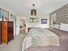 A bedroom with a bed and dresser at Paradise At 471 - Rotorua Holiday Home