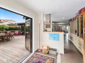 A kitchen with a door leading to a deck at Paradise At 471 - Rotorua Holiday Home, Rotorua