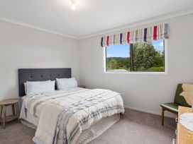 A bedroom with a bed and a window at Paradise At 471 - Rotorua Holiday Home, Rotorua