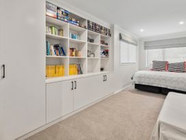 A bedroom with books on a shelf and a bed at Paradise At 471 - Rotorua Holiday Home Rotorua
