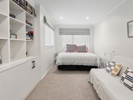 A bedroom with a bed and a sofa at Paradise At 471 - Rotorua Holiday Home Rotorua