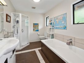 A bathroom with a shower and bathtub at Paradise At 471 - Rotorua Holiday Home in Rotorua