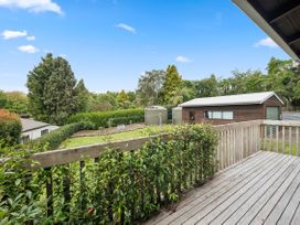 A garden view with a deck and shed at Paradise At 471 - Rotorua Holiday Home in Rotorua