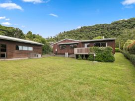 A house with a deck and lawn at Paradise At 471 - Rotorua Holiday Home in Rotorua