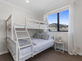 A bedroom with a bunk bed and a side table at Papamoa