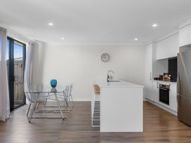 A kitchen with a dining table and appliances at Papamoa