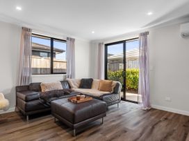 A living room with windows and sofa at Papamoa