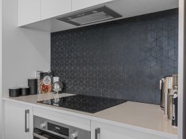 A kitchen with a cooktop and cabinets at Papamoa